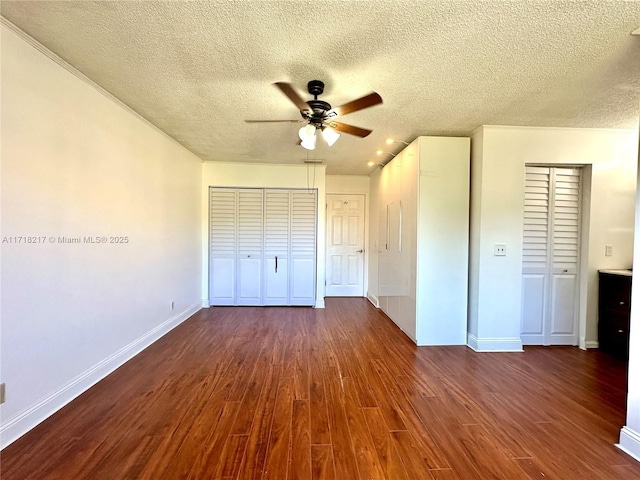 unfurnished bedroom with ceiling fan, dark hardwood / wood-style floors, and a textured ceiling