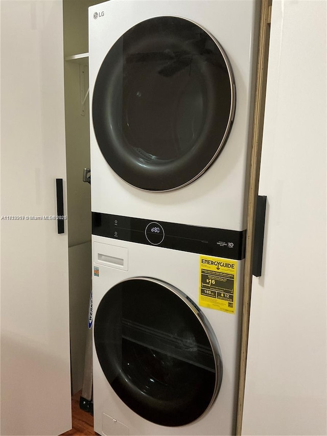 washroom featuring stacked washer and clothes dryer and hardwood / wood-style flooring