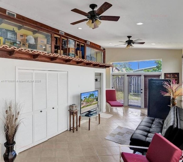 tiled living room with ceiling fan and lofted ceiling