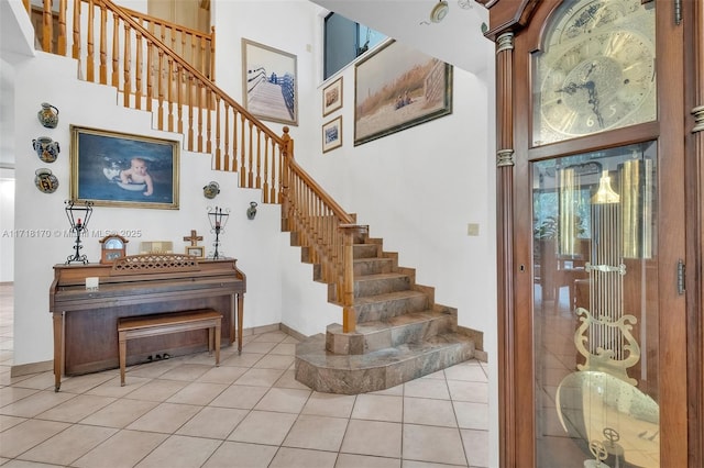 entryway featuring a towering ceiling and light tile patterned floors