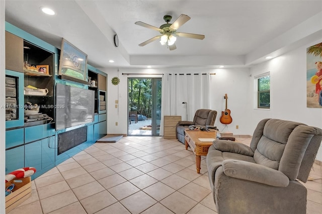 kitchen featuring ceiling fan, a kitchen breakfast bar, stainless steel refrigerator with ice dispenser, kitchen peninsula, and black oven