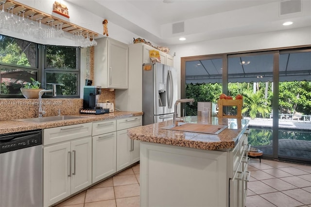 kitchen featuring backsplash, white cabinetry, light tile patterned floors, and black appliances