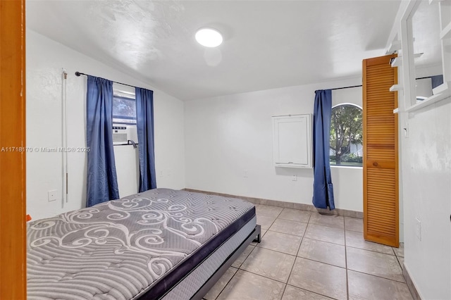 tiled bedroom featuring vaulted ceiling