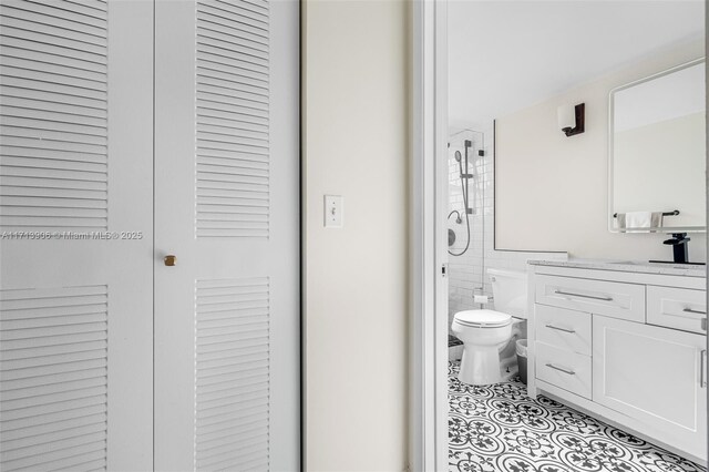 bathroom featuring vanity, tile patterned flooring, toilet, tile walls, and an enclosed shower