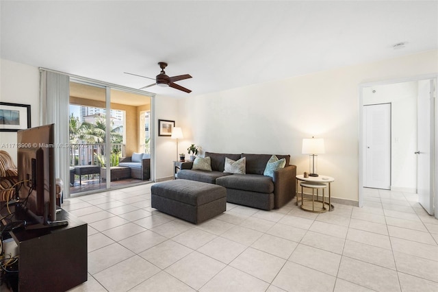 living room with ceiling fan, light tile patterned floors, and a wall of windows