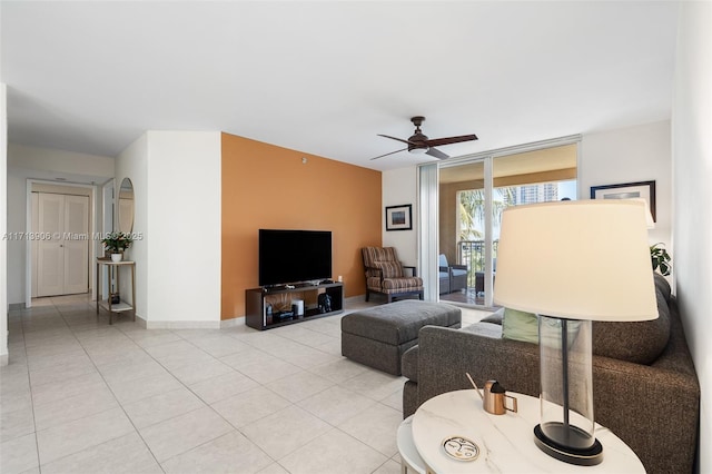 living room with ceiling fan, floor to ceiling windows, and light tile patterned flooring