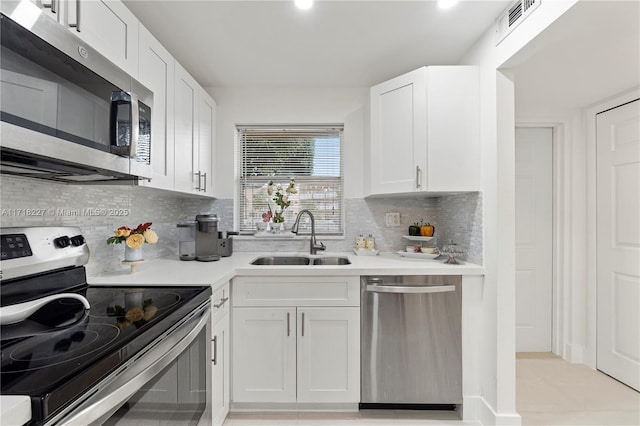 kitchen featuring white cabinetry, sink, appliances with stainless steel finishes, and tasteful backsplash