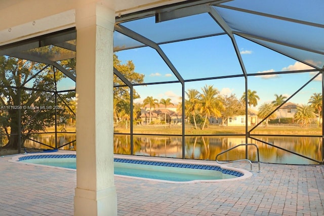 view of pool with a lanai, a water view, and a patio