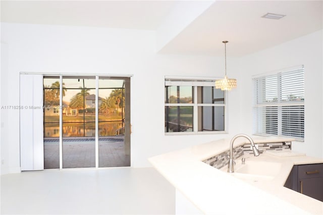 kitchen with pendant lighting, an inviting chandelier, and sink