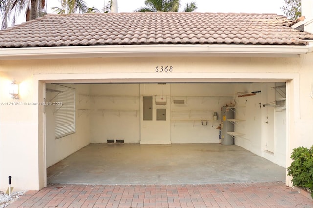 garage featuring electric panel and gas water heater