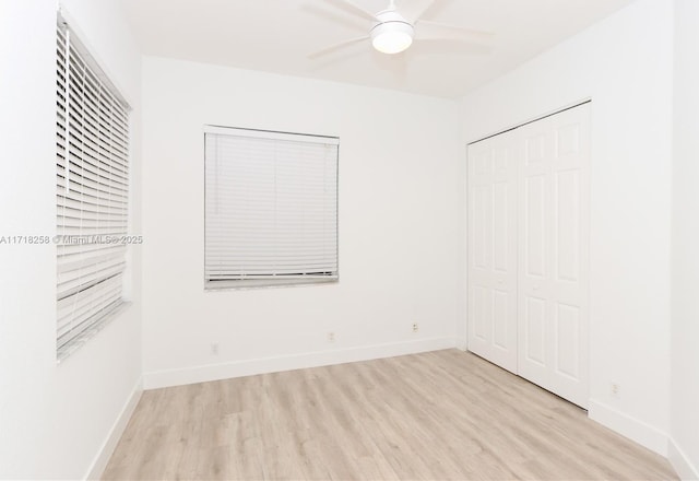 unfurnished bedroom with ceiling fan, light wood-type flooring, and a closet