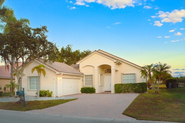 view of front facade with a yard and a garage