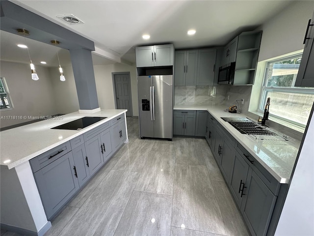 kitchen featuring pendant lighting, stainless steel appliances, gray cabinetry, and sink