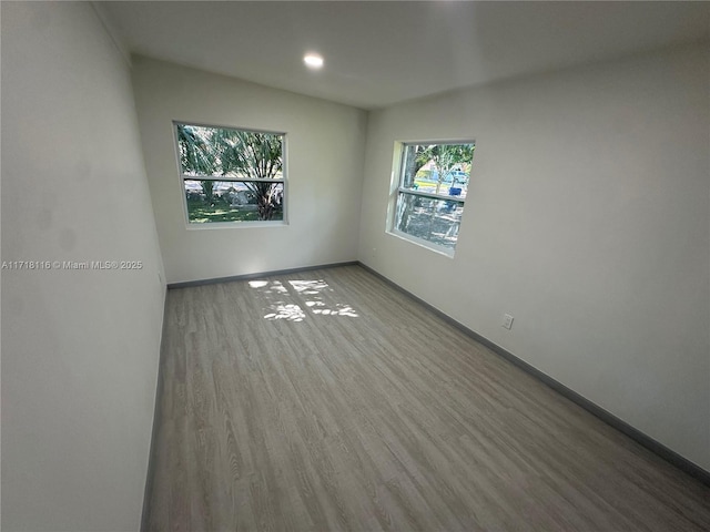 spare room with plenty of natural light and light hardwood / wood-style floors