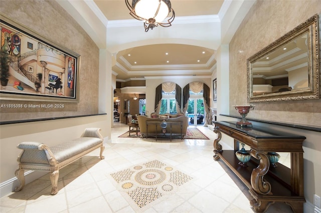 tiled foyer entrance with recessed lighting, a tray ceiling, arched walkways, and crown molding