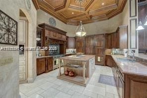 kitchen featuring a center island, range, coffered ceiling, and ornamental molding