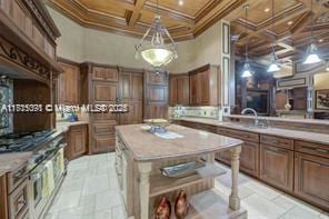 kitchen with beamed ceiling, a towering ceiling, coffered ceiling, and ornamental molding