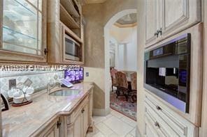 kitchen with light countertops, arched walkways, and a sink