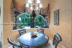 dining space featuring baseboards and an inviting chandelier