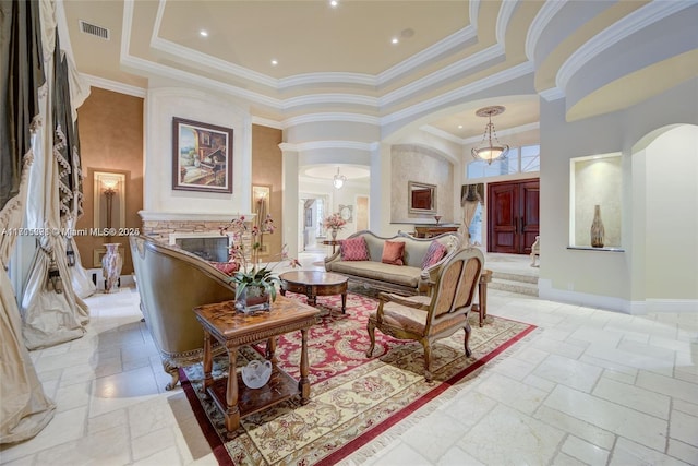 living area featuring arched walkways, visible vents, ornate columns, and stone tile flooring