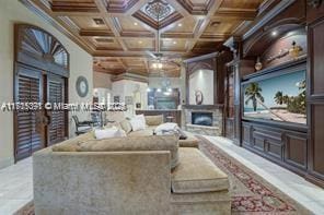 living room with a fireplace, coffered ceiling, a ceiling fan, and ornamental molding