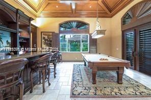 rec room featuring billiards, coffered ceiling, stone tile flooring, ornamental molding, and beamed ceiling