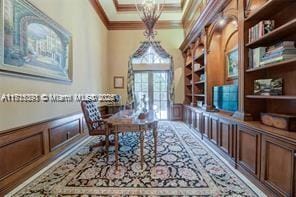 office space with coffered ceiling, beam ceiling, ornamental molding, wainscoting, and a decorative wall