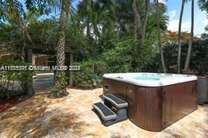 view of patio / terrace with a carport and a hot tub