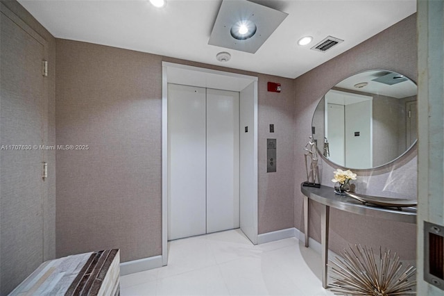 bathroom with elevator and tile patterned flooring