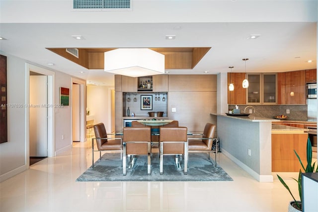 dining room with a raised ceiling and light tile patterned floors