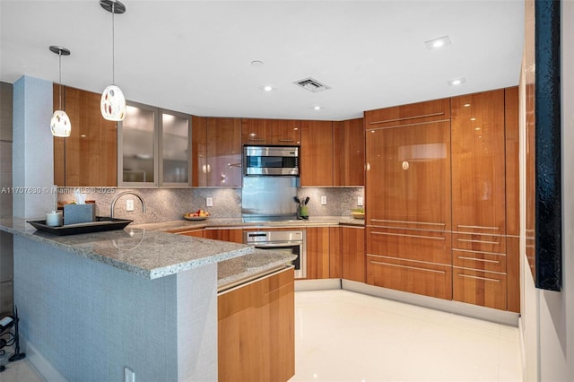 kitchen with pendant lighting, light stone countertops, appliances with stainless steel finishes, a kitchen bar, and kitchen peninsula