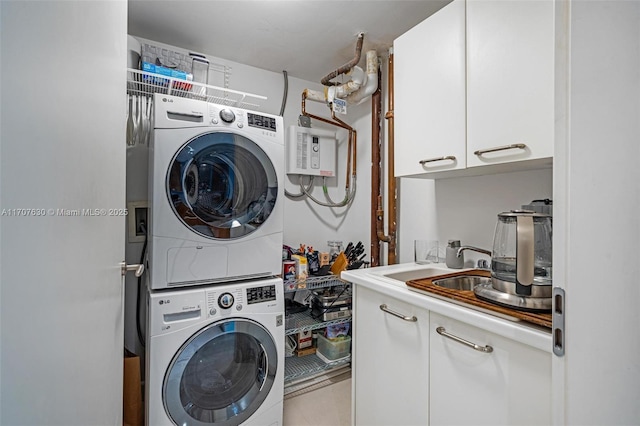 clothes washing area featuring cabinets and stacked washer and dryer