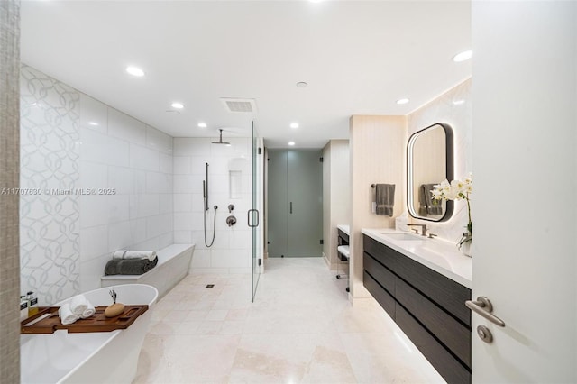 bathroom featuring vanity, tile walls, and independent shower and bath