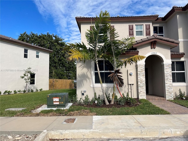 mediterranean / spanish house featuring a front lawn