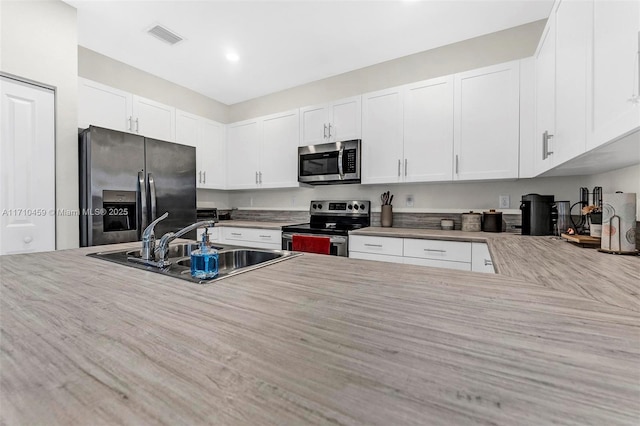 kitchen featuring white cabinets, sink, and stainless steel appliances