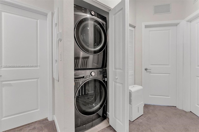 laundry area with light carpet and stacked washer and clothes dryer