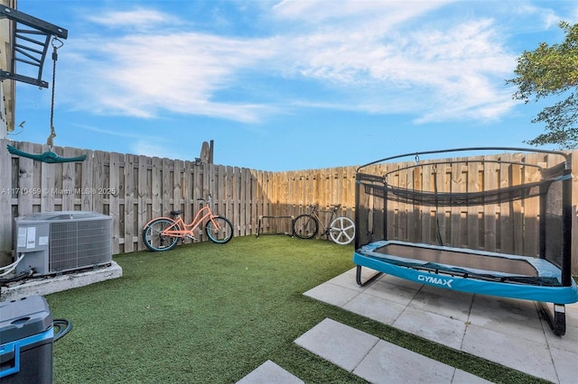 view of yard featuring cooling unit, a patio, and a trampoline