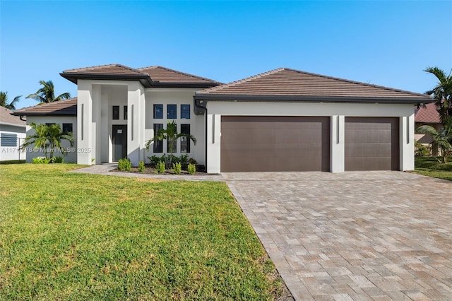 view of front of home with a front yard and a garage