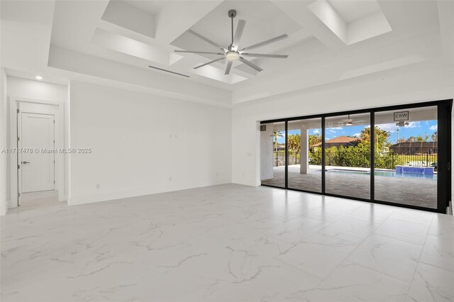 unfurnished living room with ceiling fan, sink, and a tray ceiling