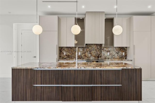 kitchen featuring pendant lighting, decorative backsplash, light stone counters, and dark brown cabinets