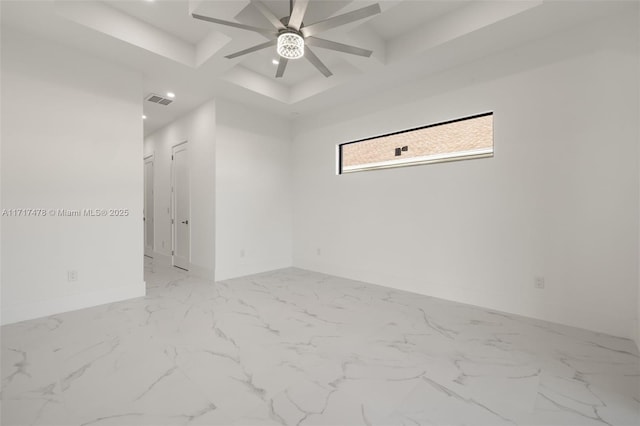 empty room featuring ceiling fan and a tray ceiling