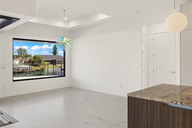 unfurnished dining area with a tray ceiling