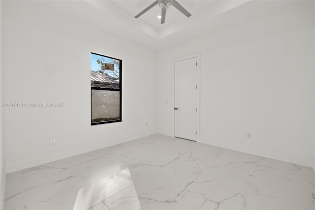 empty room with a tray ceiling and ceiling fan