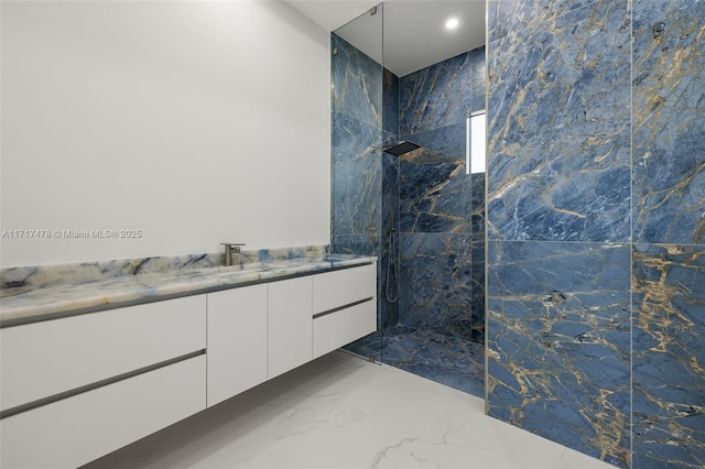 bathroom featuring a tile shower and vanity