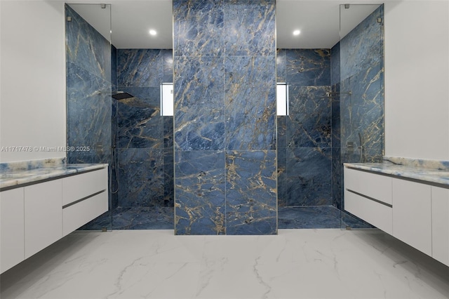 bathroom featuring a tile shower and vanity