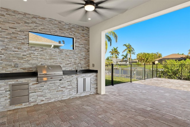 view of patio / terrace with area for grilling, ceiling fan, sink, and exterior kitchen