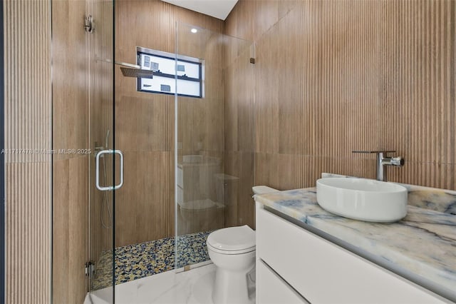 bathroom featuring tile walls, vanity, an enclosed shower, and toilet