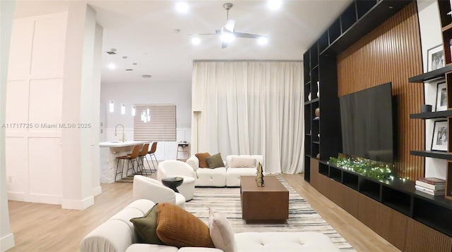 living room featuring light hardwood / wood-style flooring and ceiling fan