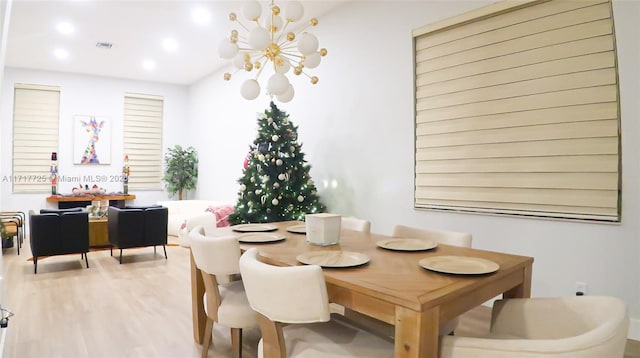 dining area featuring hardwood / wood-style flooring and an inviting chandelier