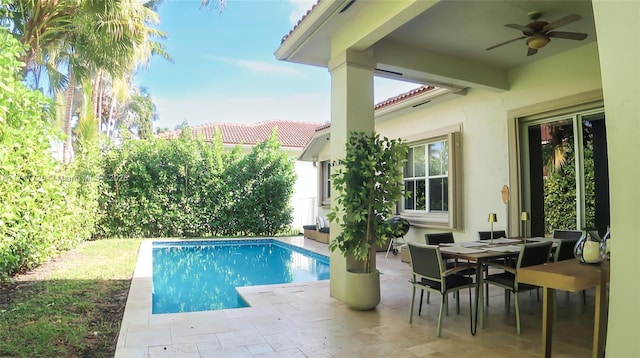 view of swimming pool featuring ceiling fan and a patio